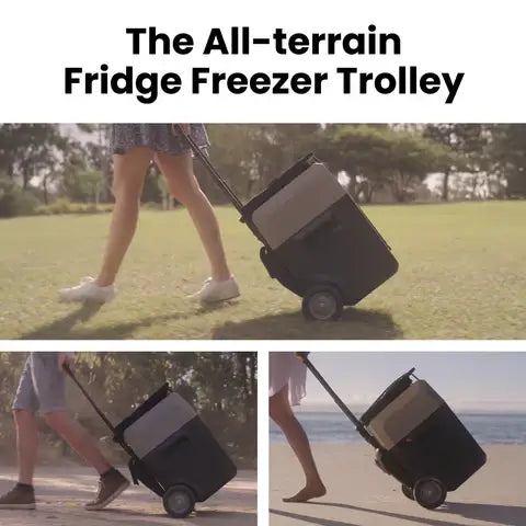 Wearing casual summer attire, a person pulls an ACOPOWER compact two-wheeled fridge freezer trolley across grass and sand. This portable refrigerator offers rapid cooling, making it perfect for outdoor adventures.