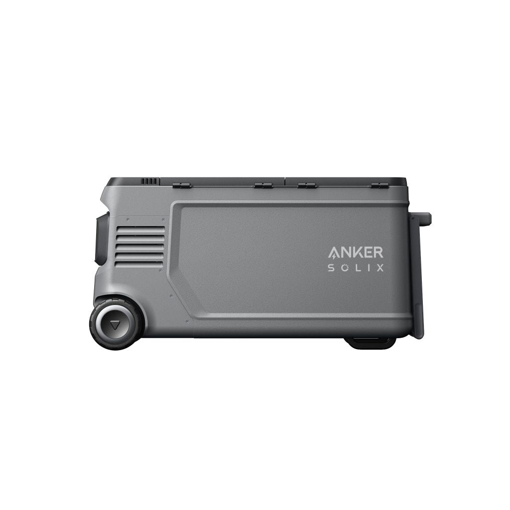 A gray Anker portable power station is pictured from the side, featuring a flat rectangular design, two visible wheels on one end, and the brand name "Anker" printed on its side.