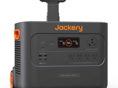 A black and orange Jackery portable power station with wheels, a handle, and an LED displaying battery percentage. It includes various outlets and buttons, prominently displaying the brand name "Jackery.