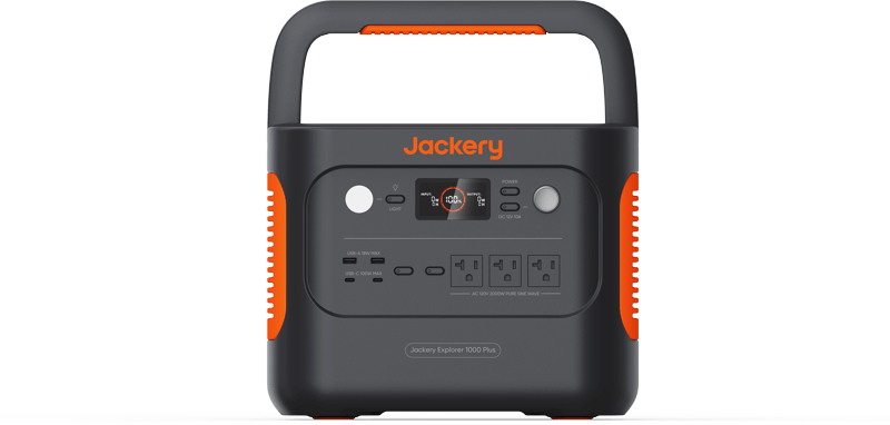 The Jackery portable power station features a digital display and multiple outlets, including AC, USB, and DC ports. Its black design includes orange accents and an integrated top handle for easy carrying.