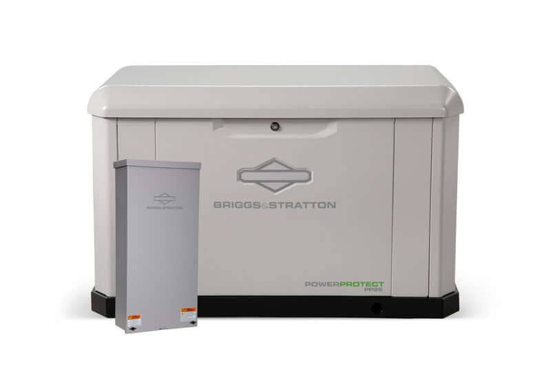 Displayed here is a large, rectangular Briggs & Stratton PowerProtect PP26 Home Standby Generator along with a smaller matching electrical panel. Both items are gray and feature the Briggs & Stratton logo. This sturdy design provides an excellent backup power solution during outages.