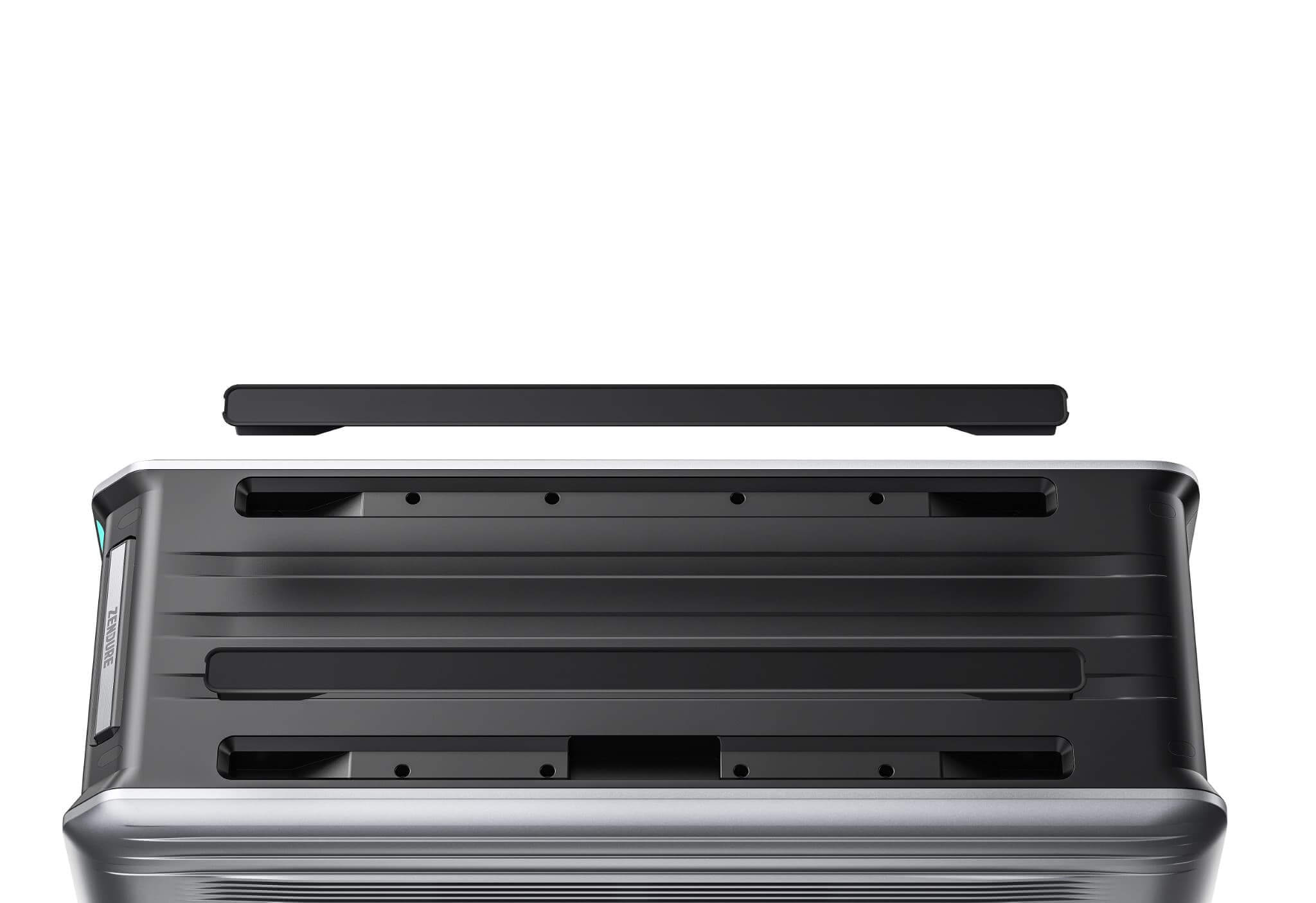 A close-up of a silver hardshell suitcase’s top with its black removable panel lifted, revealing slots and indentations—ideal for integrating a Zendure SuperBase V power station, making on-the-go emergency preparedness easy and efficient.
