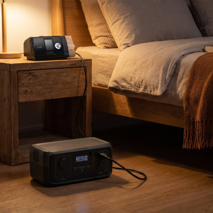 Portable power station on floor powering a CPAP machine on the nightstand