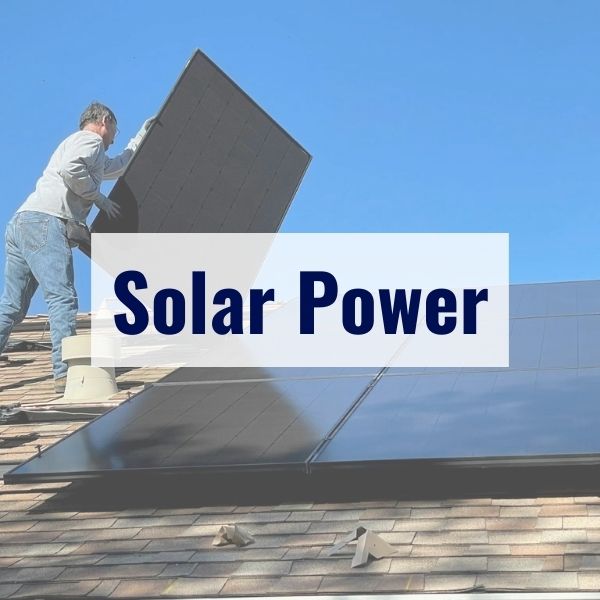 A person is installing a solar panel on the roof of a house under a clear blue sky. The large text "Solar Power" is prominently displayed in the center of the image.