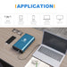 An ACOPOWER blue high-capacity power bank charges a phone and laptop on a wooden desk. Nearby are a notebook, pen, and coffee. Icons show it can also power drones, tablets, TVs—even act as a Tesla Model 3/Y/X portable freezer battery.