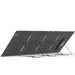 A large rectangular 400W Nature's Generator folding solar panel is propped at an angle with multiple black metal stands. Its surface features visible lines, a textured finish, and several small holes and markings along the edges.