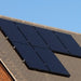 Eight Nature's Generator monocrystalline solar panels, each mounted securely on the sloped roof of a house, stand out against the clear blue sky.