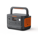 A portable power station from Jackery with an orange and black design features a digital display, USB ports, AC outlets, input/output options, and a top handle for easy carrying.