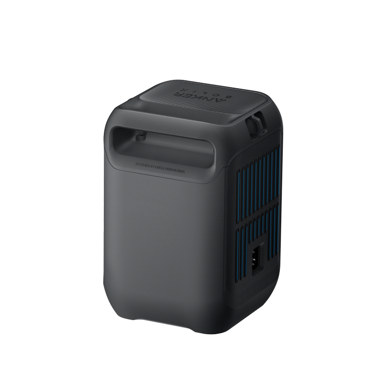 The Anker portable power station is a sleek black rectangle with side ventilation grilles, a top carrying handle, and a clearly visible electrical outlet for easy access.