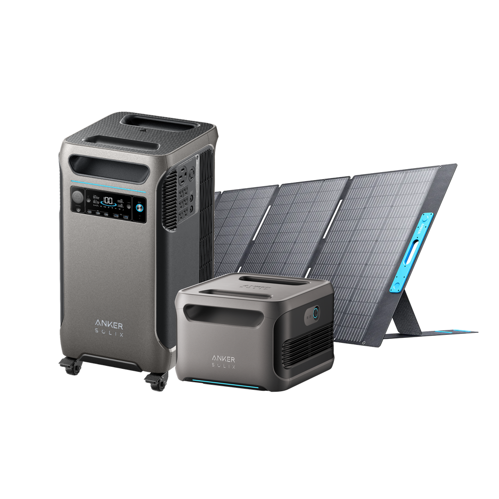 Two Anker SOLIX F3800 power stations equipped with digital displays are set next to a foldable solar panel. The taller, mobile power station features wheels for easy transportation, while the solar panel is angled for optimal energy absorption.