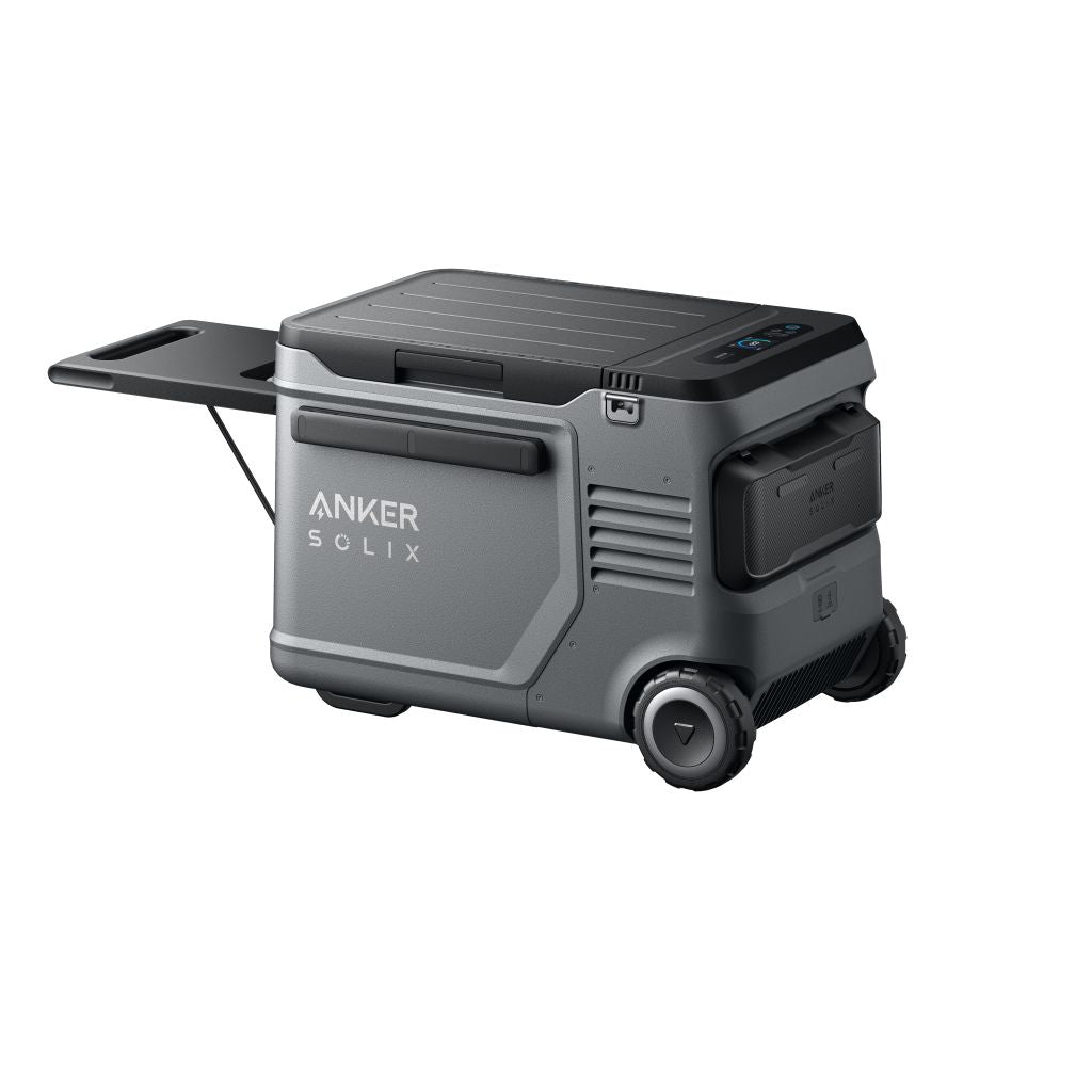 The Anker Solix portable power station in gray features wheels, a pull-out handle, multiple compartments, and a control panel on the top right. It's ideal for pairing with an electric cooler and is shown against a white background.