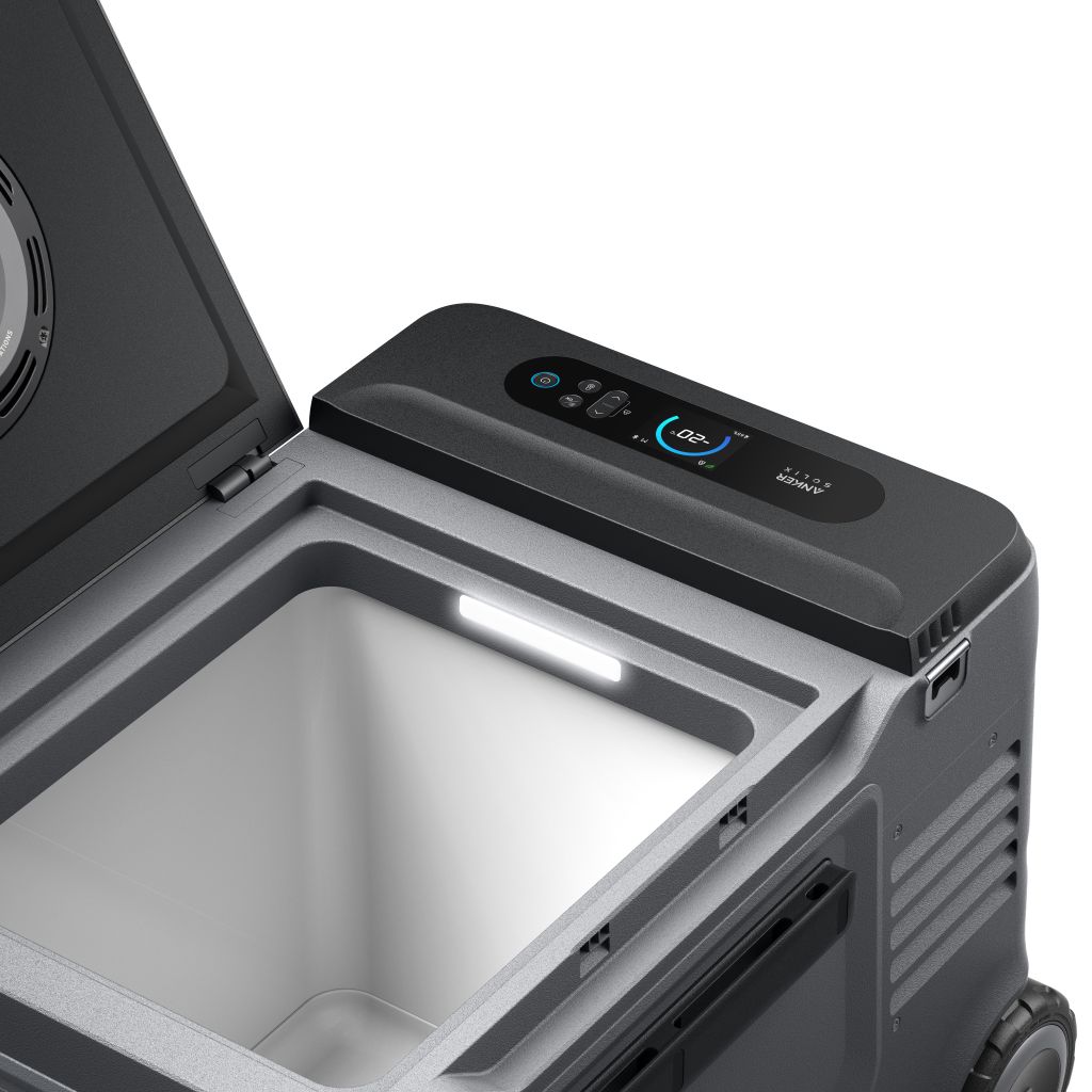 An Anker open portable solar cooler featuring a digital control panel with temperature display, interior LED lighting, and an empty compartment is shown in a well-lit environment.