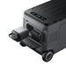 The Anker portable solar cooler is shown with wheels, a handle, a top control panel, and two removable battery modules, one partially pulled out from the front compartment.