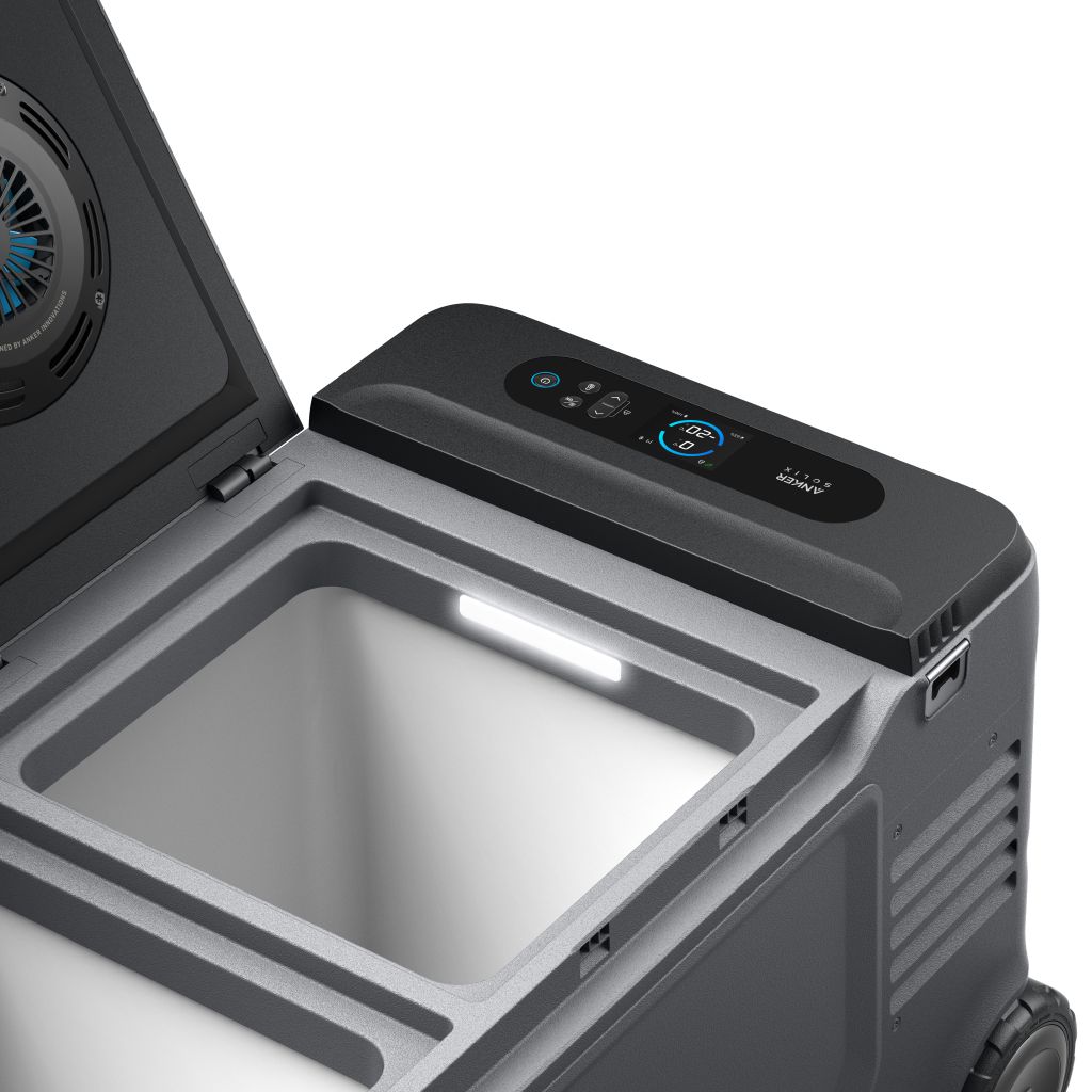 Anker portable electric cooler with open lid reveals an empty interior, built-in light, and digital control panel on the top edge showing temperature settings.