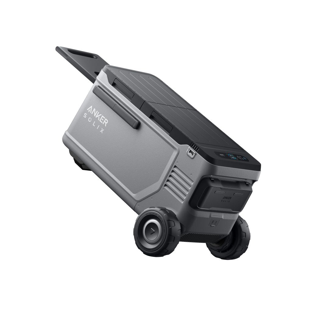 A gray and black Anker portable power station with wheels, a handle, control buttons on the front, and a solar panel on top.