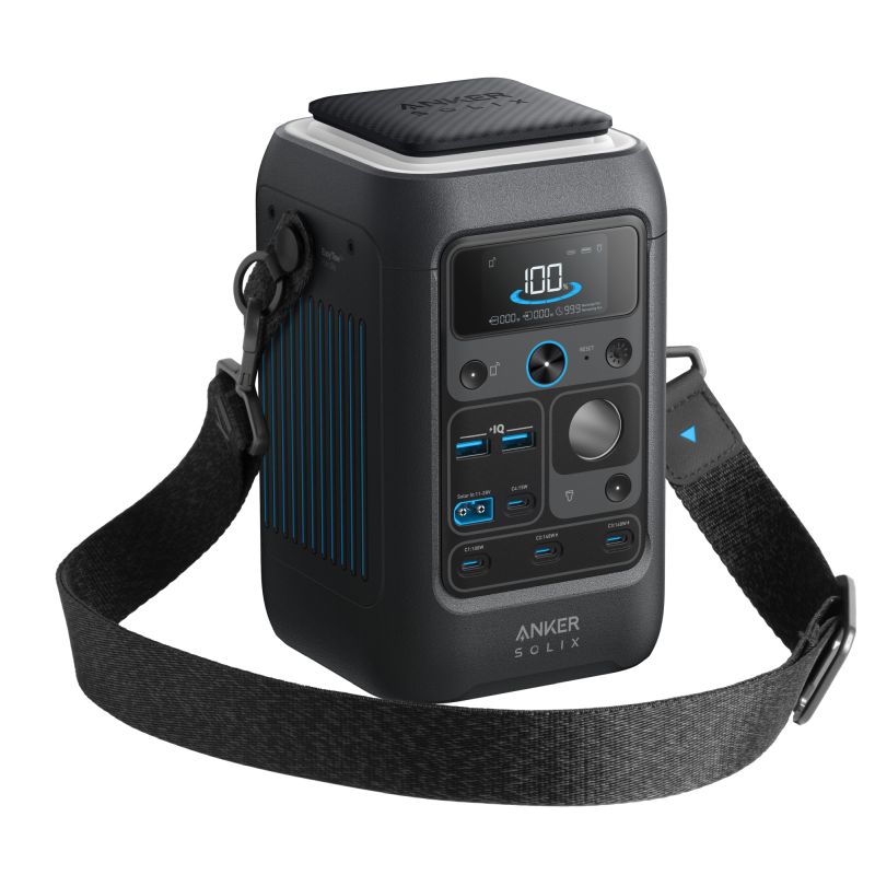 A black Anker portable power station with a digital display, multiple ports and buttons, a carrying handle, and an attached shoulder strap—styled like modern web design. The device features the Anker logo at the bottom.