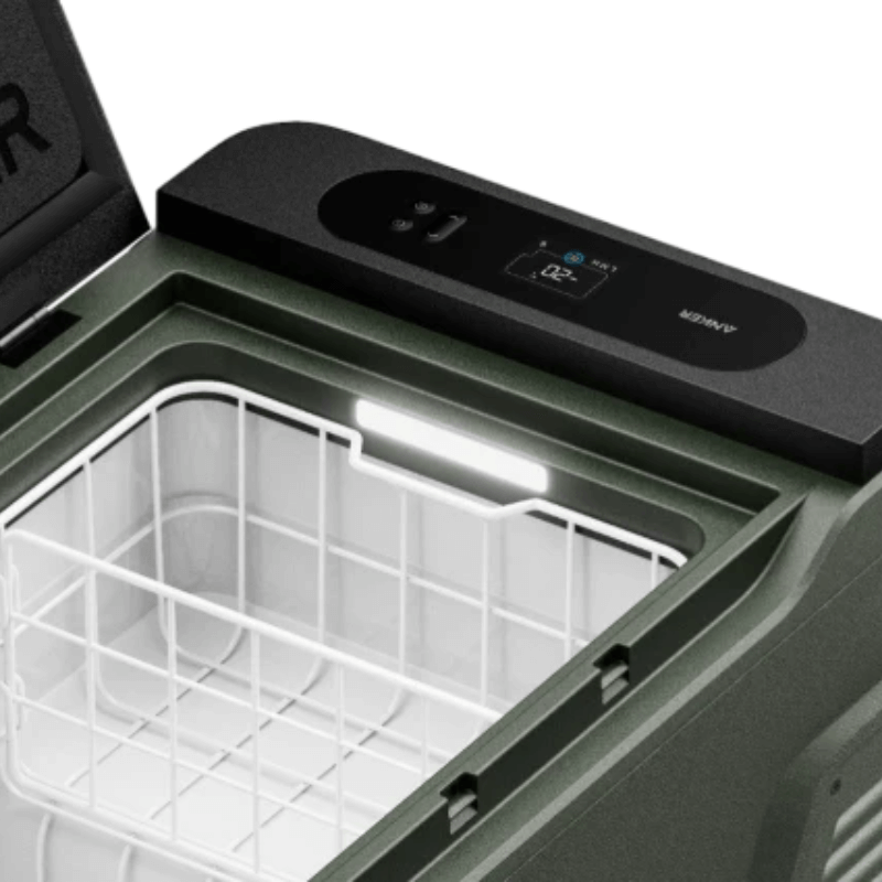 When opened, the Anker EverFrost reveals its illuminated storage area with a ready-to-use wire basket. The digital display and control buttons on the lid complement the sleek design of this battery-powered cooler, which is angled to highlight its efficient portability.
