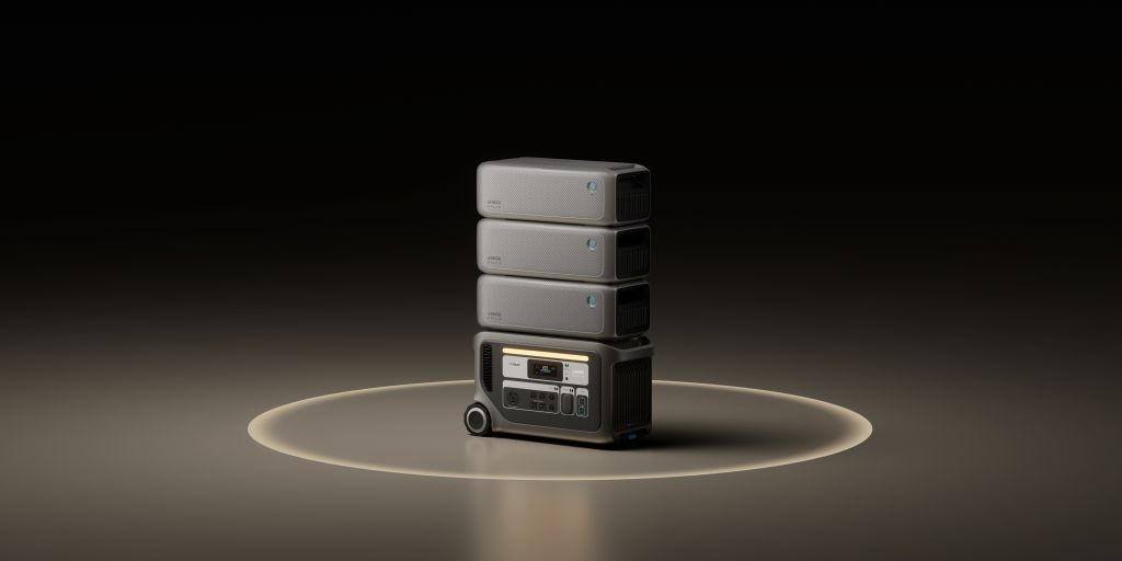 A sleek black Anker SOLIX F3000 + Expansion Battery by Anker, featuring a display and control panel, is stacked with three matching battery packs atop it on a softly lit circular platform.