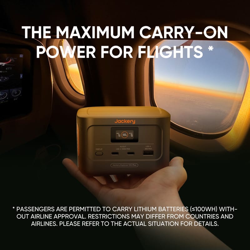 A hand presents a Jackery power station before an airplane window. The text reads, "Jackery: Max Carry-On Power for Flights*." Below, a disclaimer notes that lithium battery restrictions depend on the country and airline.