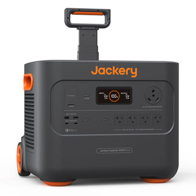 A black and orange Jackery portable power station with wheels, a handle, and an LED displaying battery percentage. It includes various outlets and buttons, prominently displaying the brand name "Jackery.