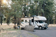 EcoFlow DELTA Pro with a portable solar panel charging beside an RV at a campsite
