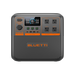 A Bluetti portable power station featuring four AC outlets, a digital display, and multiple input/output ports on the front panel. The device sports a gray and black design with orange accents and branding.