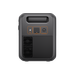 A black Bluetti portable power station features a handle on top, two buttons, a circular port, and diagonal ventilation slats on the lower half. Orange accents highlight the controls and ports, set against a light gray background.
