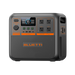A portable Bluetti power station features a digital display, multiple control buttons, four AC outlets, DC outputs, and distinctive orange accents on a compact, black rectangular unit.