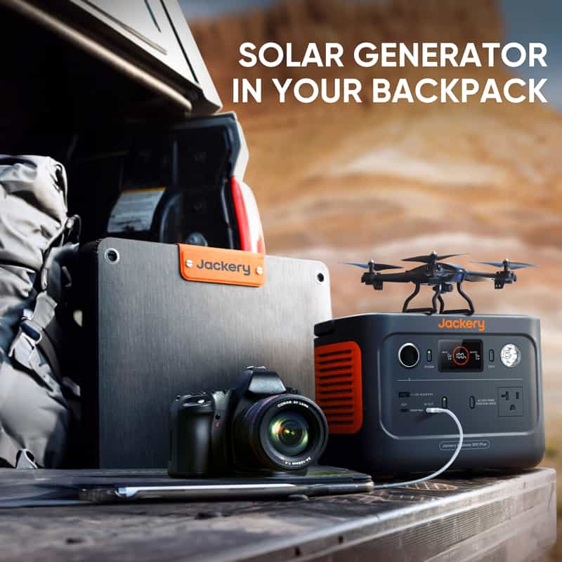 A Jackery solar generator sits on a vehicle's tailgate, surrounded by a camera, foldable solar panel, and small drone against a desert backdrop. The image displays the text "Solar Generator in Your Backpack.