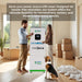 A man and woman stand next to a Nature's Generator portable power system with a LiFePO4 Battery in a room with moving boxes and their dog. Text highlights its flexible, reliable whole home backup for homeowners, renters, and temporary spaces.