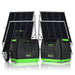 Two Nature's Generator portable solar generators with control panels are set in front of four standing solar panels—ideal for off-grid power or home backup. The black units have green accents; one features wheels and a handle for easy transport.