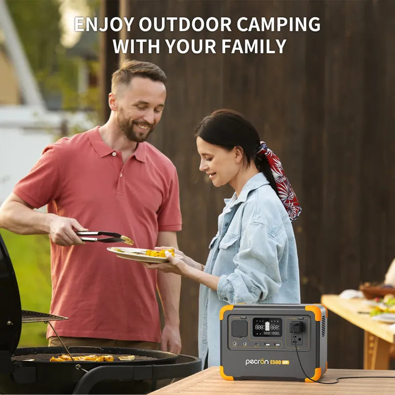 A man wearing a red shirt is cooking food outside on a grill, using tongs to serve a woman with a ponytail who is holding a plate. Next to them, the Pecron E500LFP powers their activities with its LiFePo4 Battery and 600W AC Pure Sine Wave Inverter. Text above them reads, "Enjoy outdoor camping with your family.