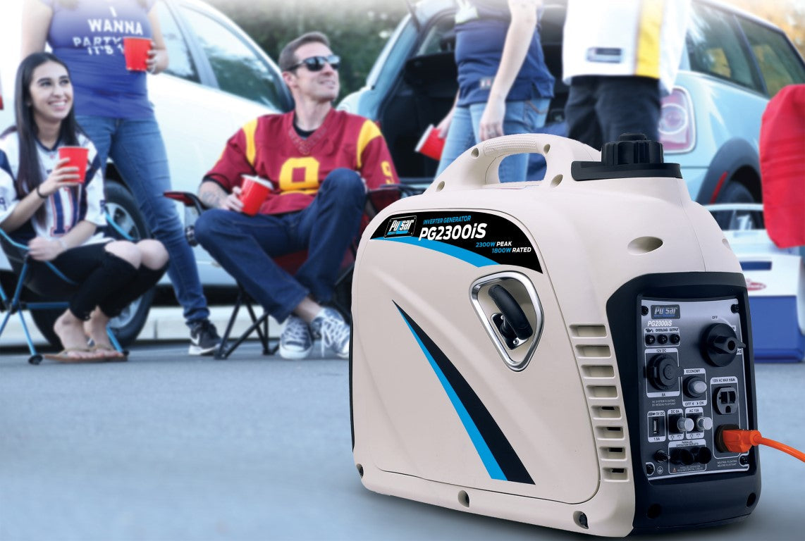 A quiet Pulsar portable generator sits on the ground in front, while people relax in folding chairs by parked cars in the background, likely tailgating.