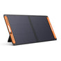 The Jackery SolarSaga 100W Solar Panel features two black panels, orange handles, and a built-in kickstand—delivering portable energy with style and convenience against a plain white background.