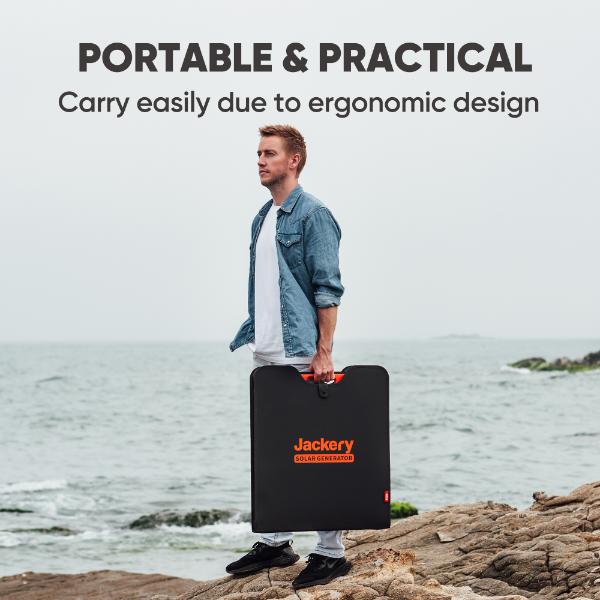 A man stands on rocky ground by the sea, holding a Jackery solar generator case. The text above reads: "PORTABLE & PRACTICAL. Outdoor enthusiasts can easily carry this Jackery energy solution thanks to its ergonomic design.