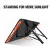 A Jackery solar panel stands on adjustable legs, optimizing its angle toward the sun. Above, bold text states, “STANDING FOR MORE SUNLIGHT.” Orange arrows highlight the portable energy solution’s easy adjustment mechanism.