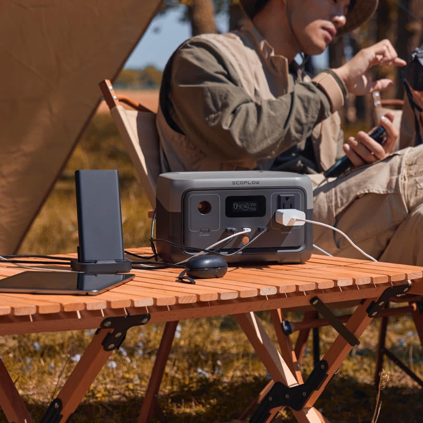 RIVER 2+ portable generator charging phone and laptop at picnic table