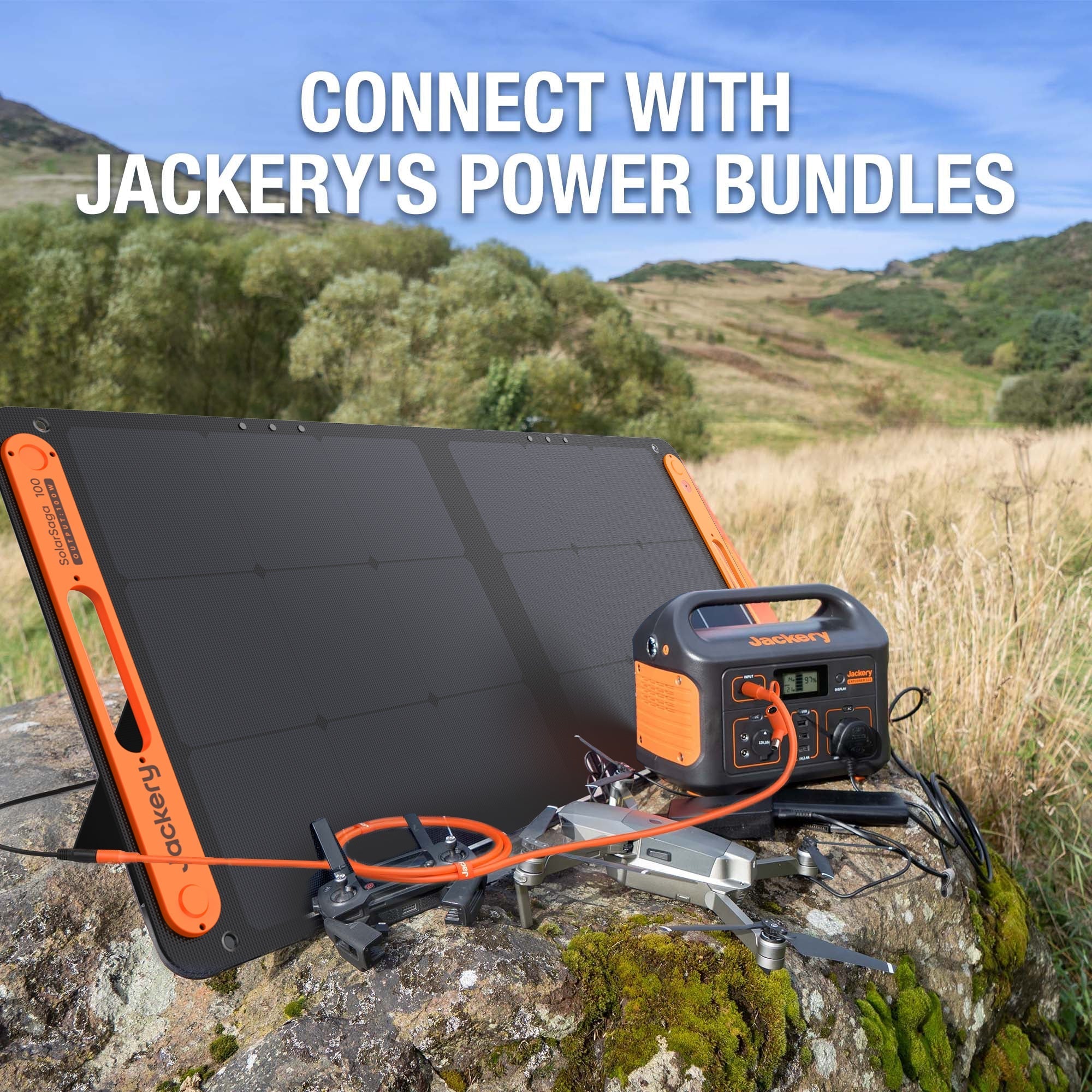A Jackery power station and solar panel sit on a rock in a grassy, hilly landscape with "CONNECT WITH JACKERY'S POWER BUNDLES" displayed above.