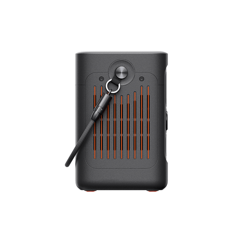 The Jackery portable power station is a compact, black rectangular device with vertical orange slats, a round button near the top, and a black carrying strap on the side, making it ideal for use on the go.