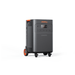 The Jackery Explorer 5000 Plus portable power station features wheels, a handle, multiple front-panel outlets and controls. Finished in dark gray with orange accents and “Jackery” at the top, it’s ideal for backup power needs.