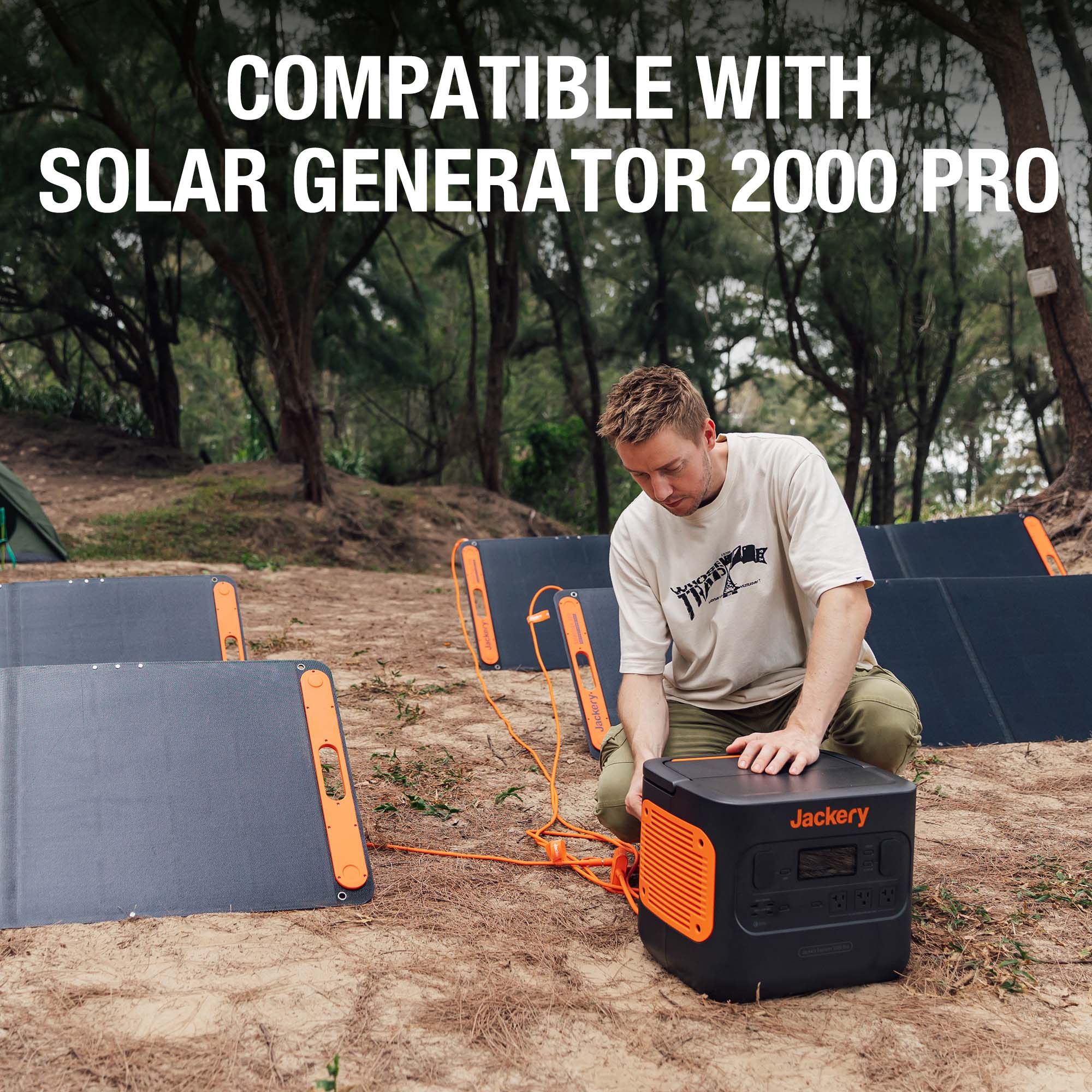 Outdoors, a person kneels while connecting orange cables from several solar panels to a Jackery portable power station using a solar panel connector. Trees and tents are in the background. Text reads, “Compatible with Solar Generator 2000 Pro.”.