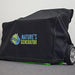 A Nature's Generator portable generator with wheels sits on a gray carpet, covered by a durable 600D polyester Nature's Generator cover featuring green and blue text and logo, against a white wall.