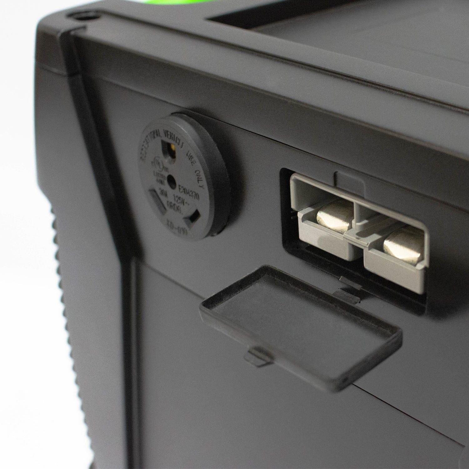 Close-up of a black Nature's Generator device featuring two rectangular ports behind an open plastic cover and a round socket labeled "Essential Plug," designed for home battery backup or off-grid power.