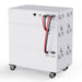 A large, rectangular white Nature's Generator home battery backup unit with multiple latches, vents, and handles, connected by red and black cables, sits on four caster wheels against a plain white background.