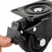 A close-up of a hand pressing the "OFF" tab on the brake of a black swivel caster wheel with metal mounting plate, perfect for upgrading generator wheels on Nature's Generator systems.